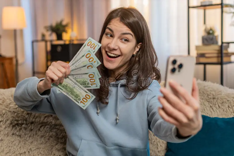 Real results — a young woman holding cash and a smartphone
